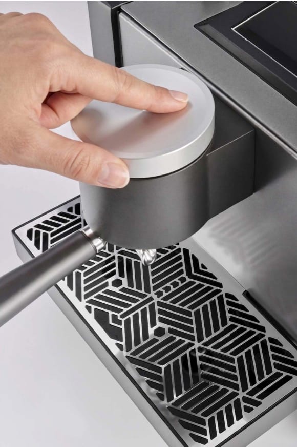 A hand on the setting knob of the Heylo Coffee Unit